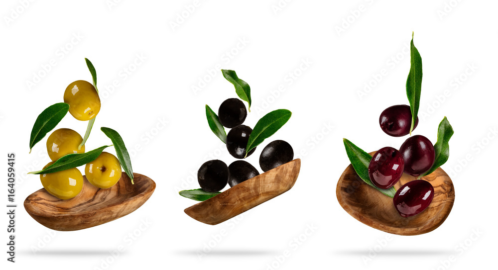 Collection of flying olives in wooden bowls on white background