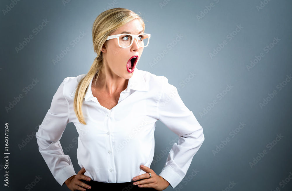 Unhappy young woman on a gray background