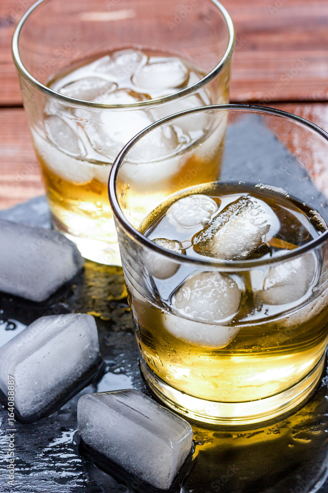 glass of whiskey on wooden background