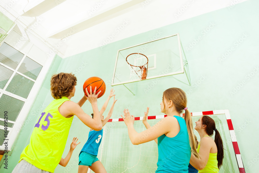 Basketball match with girls defending against boy