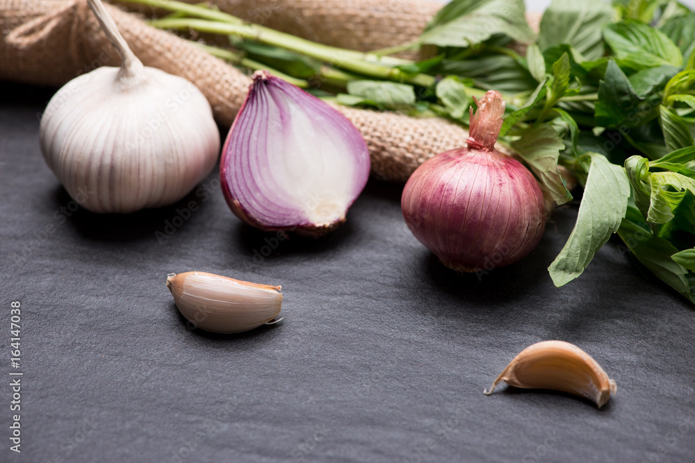 Garlic and onion on the black stone table