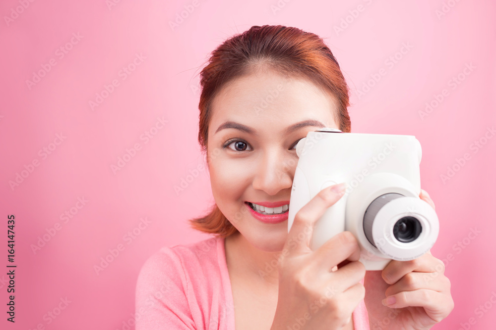 Young woman taking a photo with a camera.