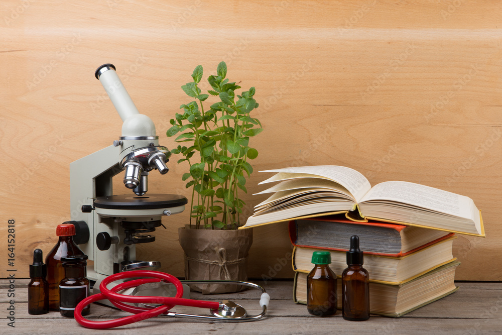 Education concept - books and microscope on the desk in the auditorium