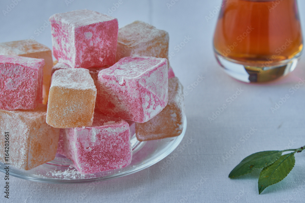 Delicious Turkish delight with tea on a wooden background