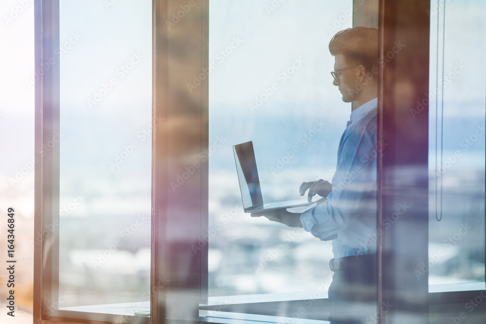 Businessman inside office building and working on laptop