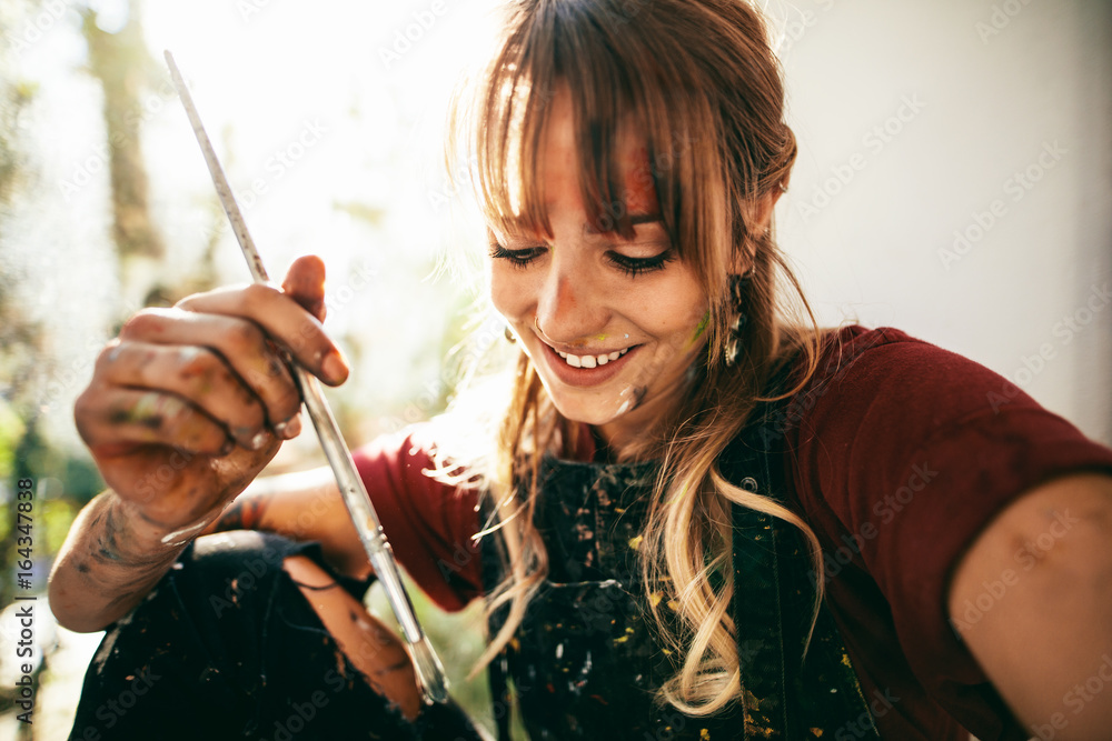 美丽的年轻女艺术家用画笔