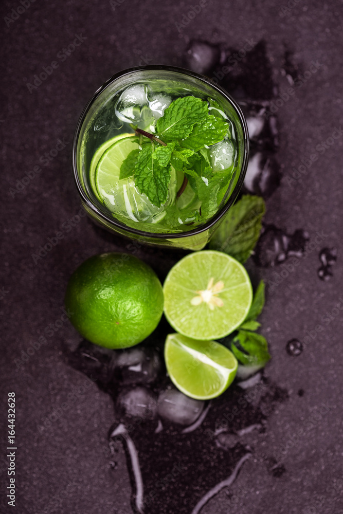 Close up top view or overhead shot of  the fresh mojito cocktail with fresh lime and mint leaf on bl