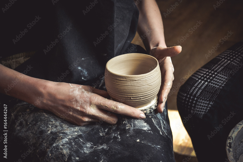 A raw clay pot in the hands of a potter