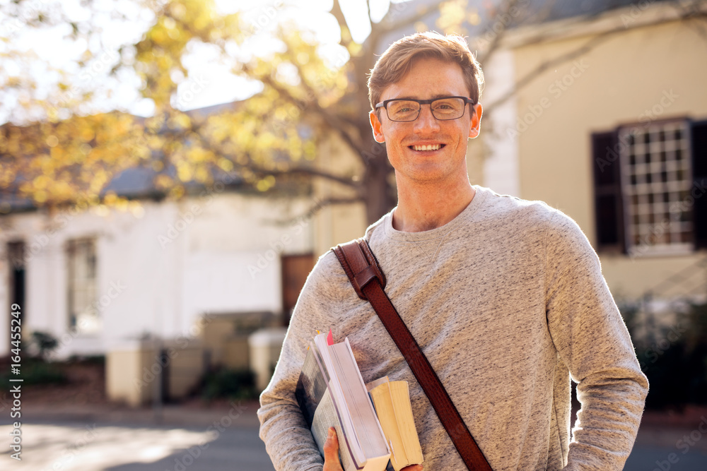 Happy male college student outdoors