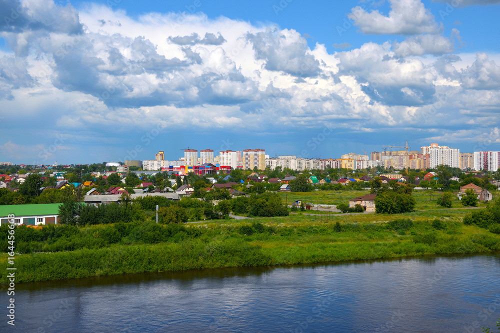 Construction of a new microdistrict in the Siberian city against the backdrop of the river and ship.