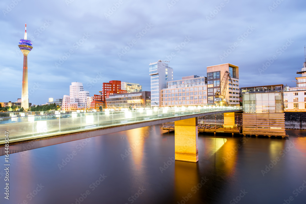 Night view on the Rhein river with illuminated buildings and television tower in Dusseldorf city, Ge