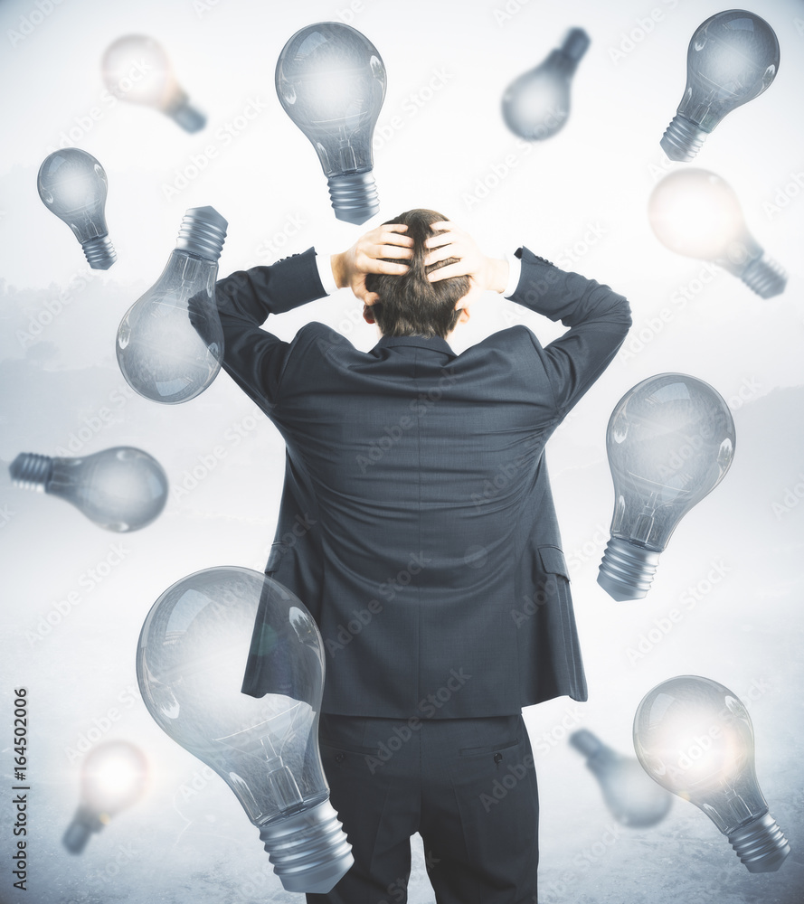 Worried businessman on lightbulb background