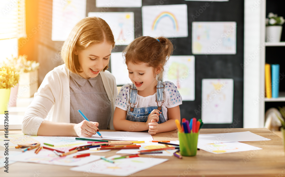 mother and child daughter draws in creativity in kindergarten