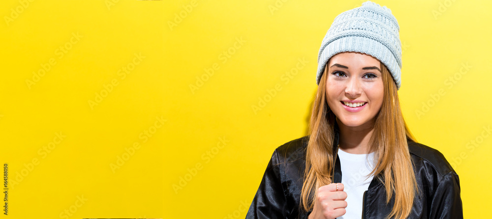 Girl wearing a black jacket on a yellow background