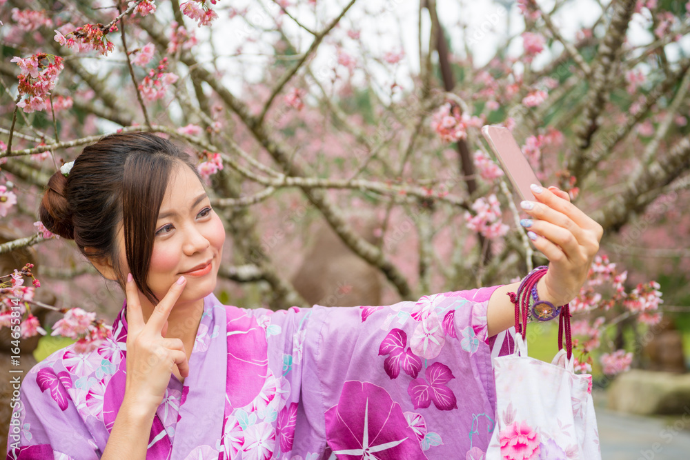 亚洲女孩在樱花公园自拍