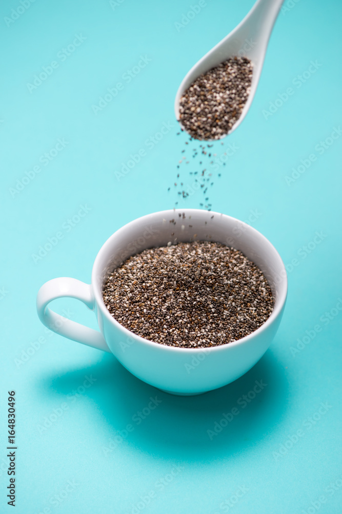 Cup of healthy chia seeds and spoon. Text space.