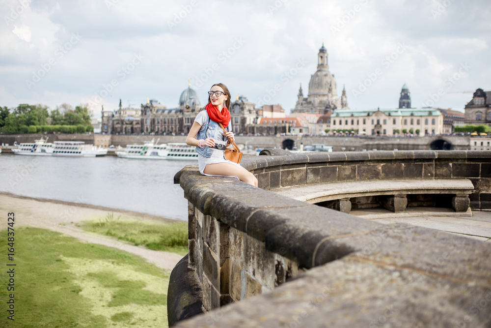 Lifestyle portrait of a stylish woman on the bridge traveling in Dresden city, Germany