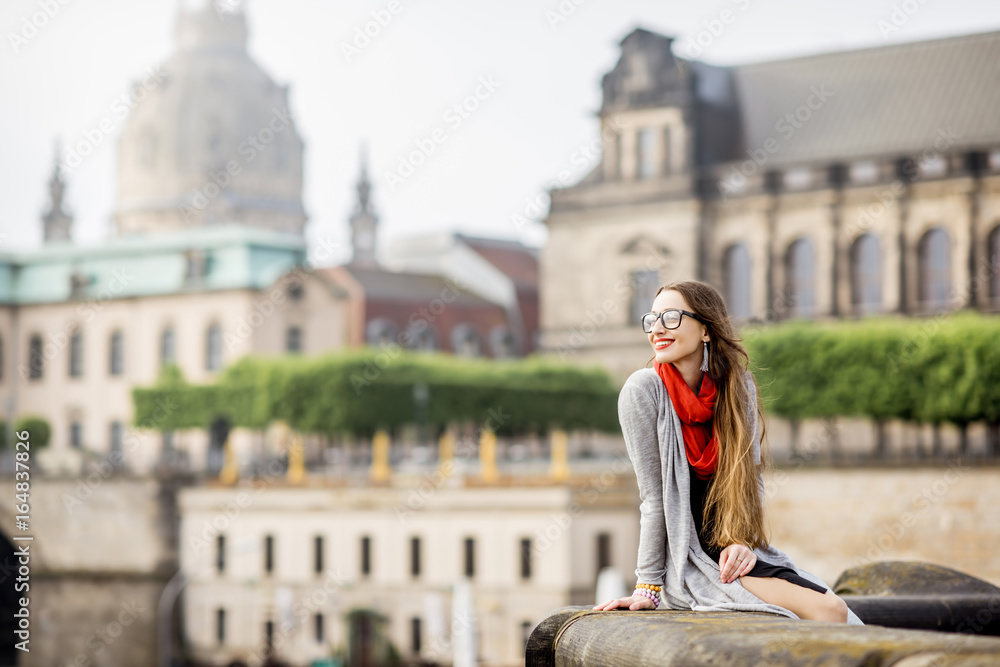 Young woman tourist with photo camera enjoying great view from the bridge on the old town of Dresden