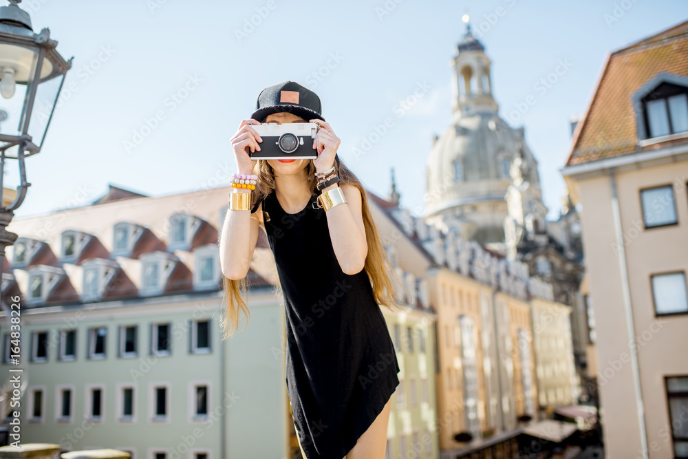 Young woman tourist standing with photo camera on the famous Bruhl terrace with great view on the ol