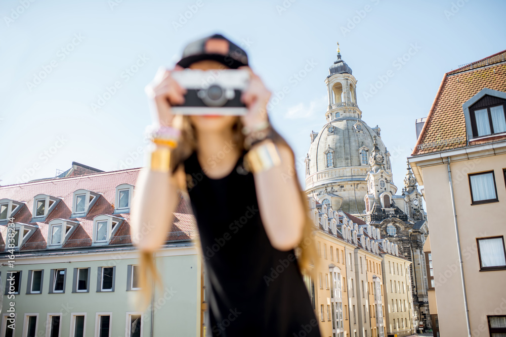 Young woman tourist standing with photo camera on the famous Bruhl terrace with great view on the ol