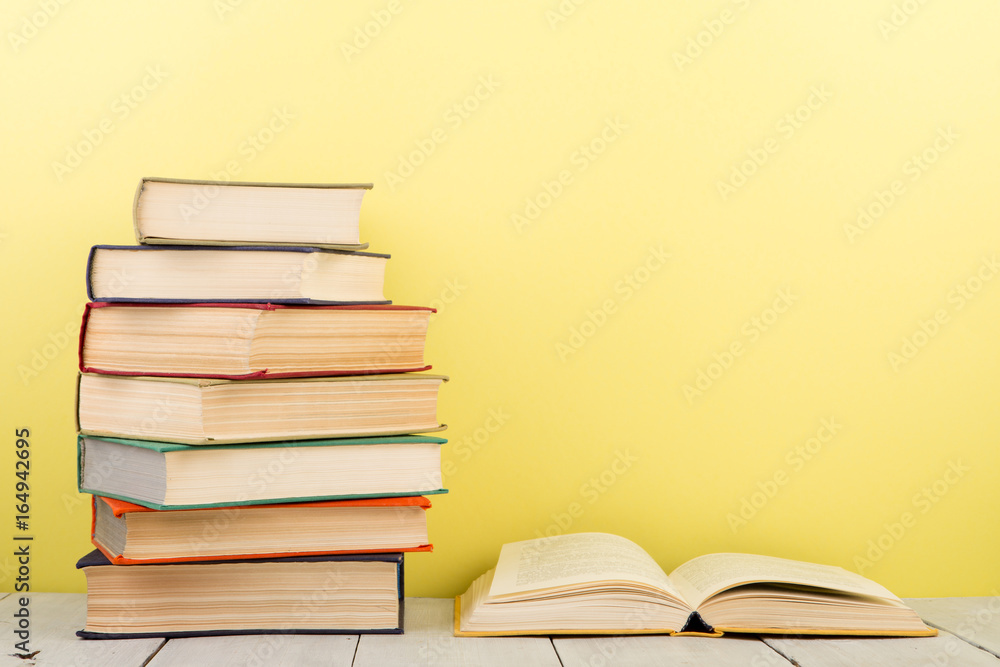 education and wisdom concept - open book on wooden table, color background