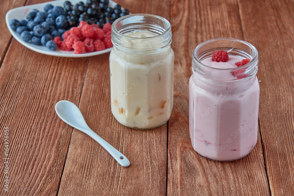 Delicious, healthy yogurt with fresh berries. Black currant, raspberry, blueberries and yogurt on a 