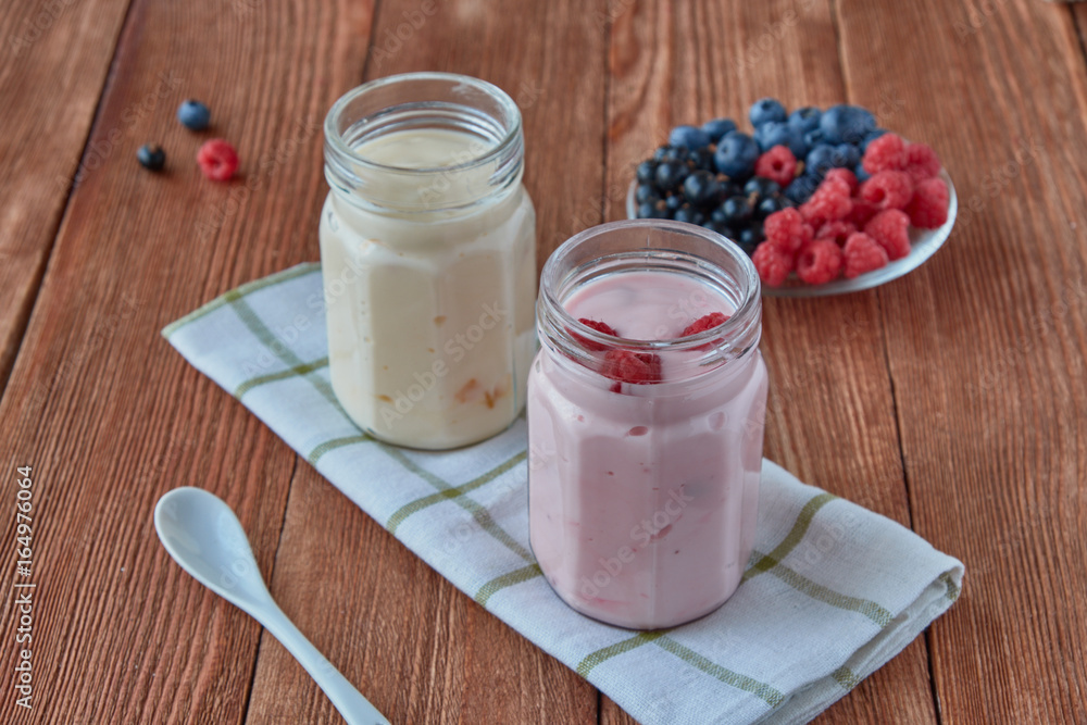 Delicious, healthy yogurt with fresh berries. Black currant, raspberry, blueberries and yogurt on a 