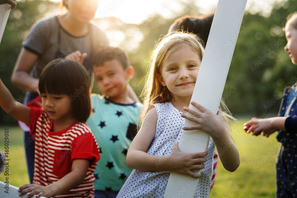 Group of kindergarten kids friends playing playground fun and smiling