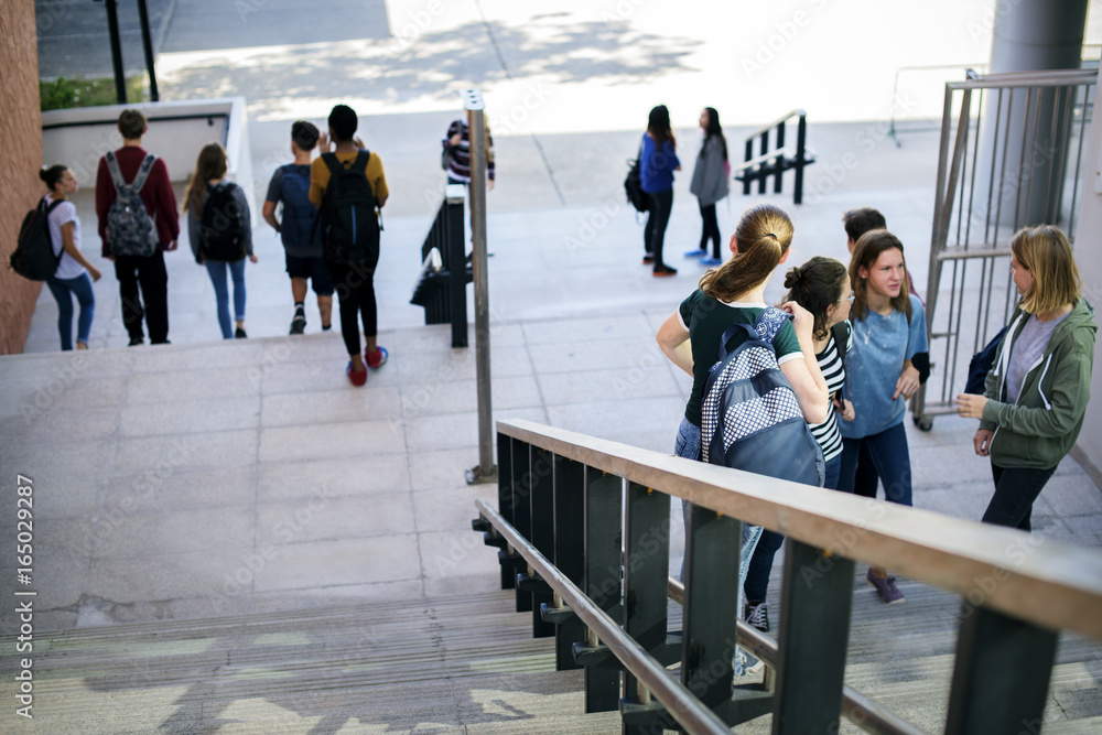 Group of school friends walking down staircase