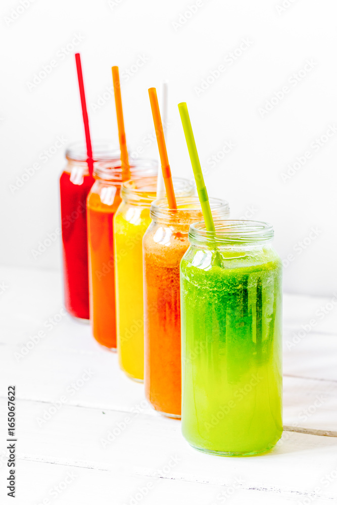 Fresh detox juices glass in row bottles on white background