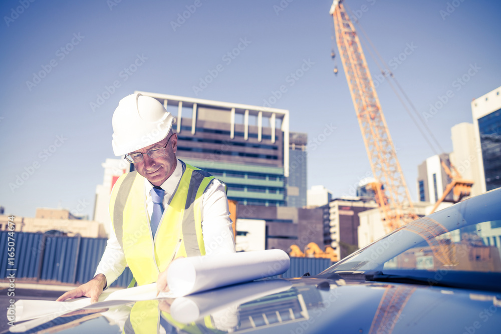 Senior foreman in glasses doing his job at building area on car 