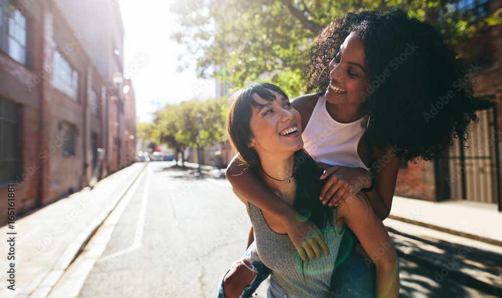 Two young woman having fun on city street