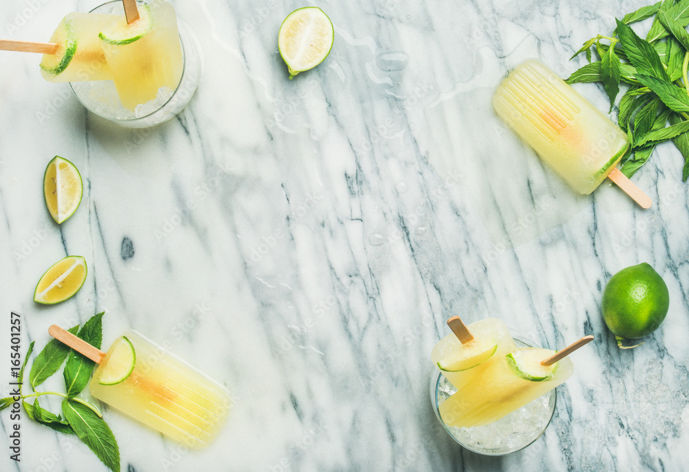 Summer refreshing lemonade popsicles with lime and mint in glasses with chipped ice, flat-lay, top v