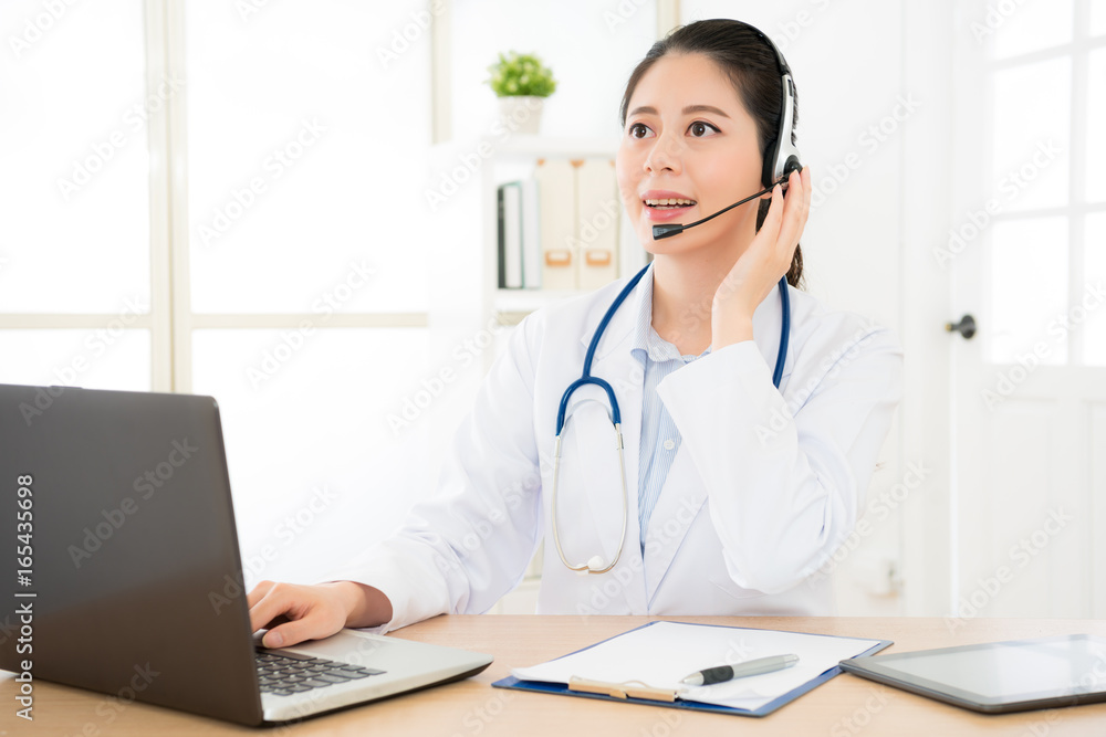 smiling female doctor holding on the headphone