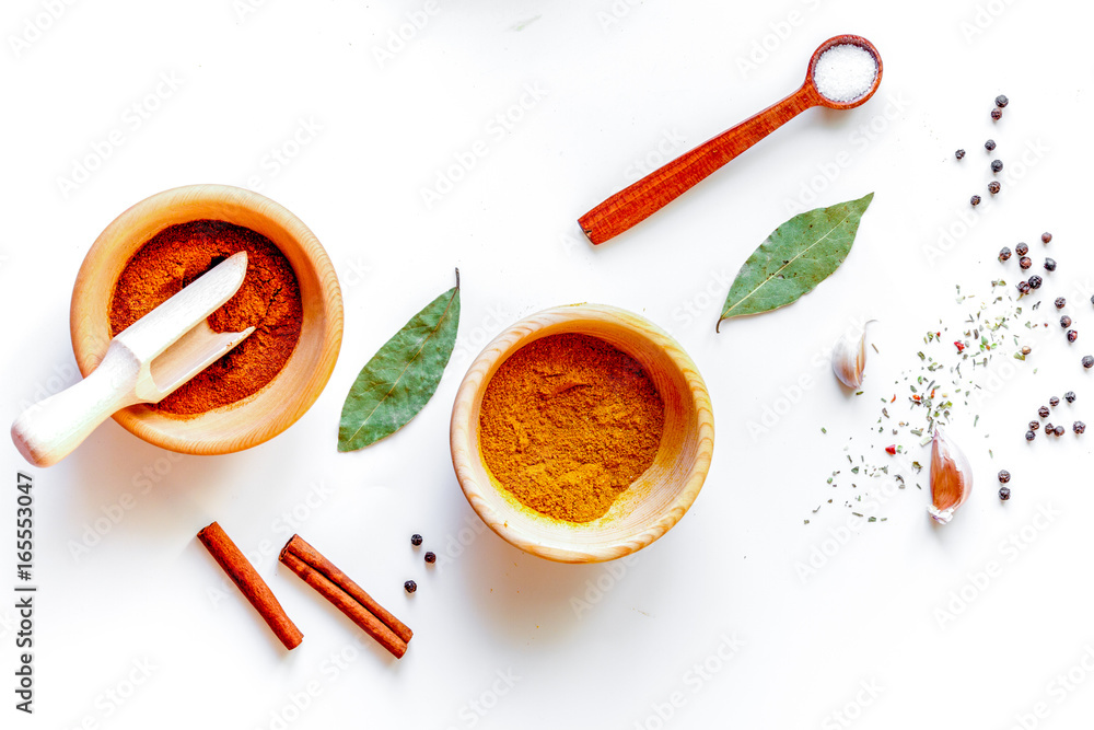 spices in wooden bowl white background top view