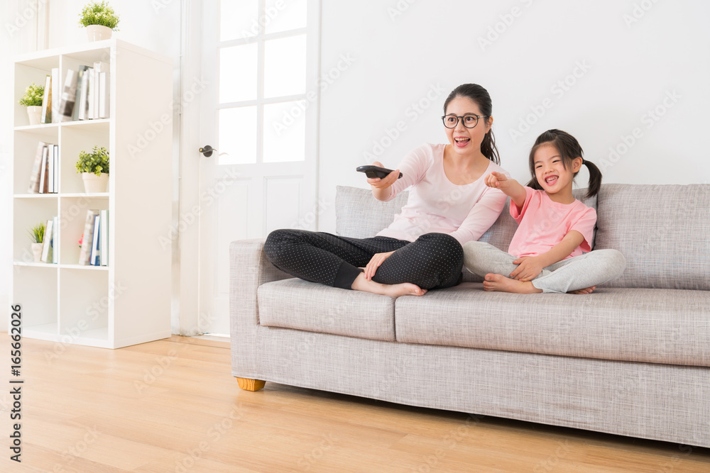 young asian mother holding a remote control