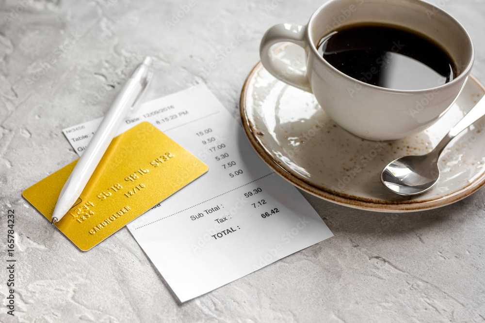 paying check for lunch in cafe with credit card on stone table background