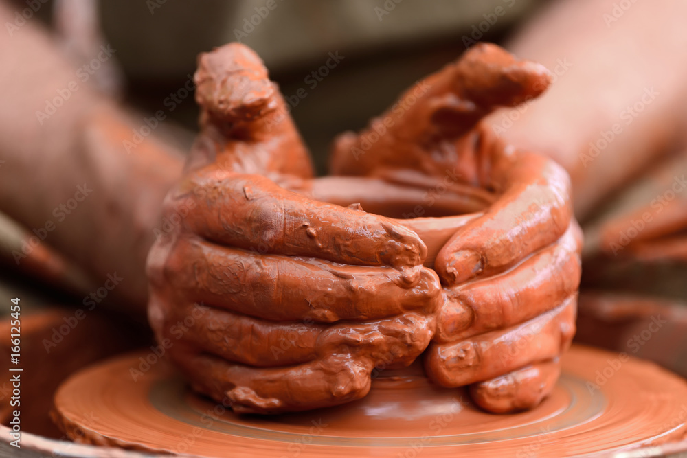 Potter making ceramic pot on the pottery wheel