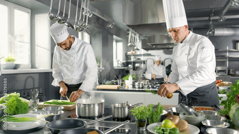 Two Famous Chefs Work as a Team in a Big Restaurant Kitchen. Vegetables and Ingredients are Everywhe