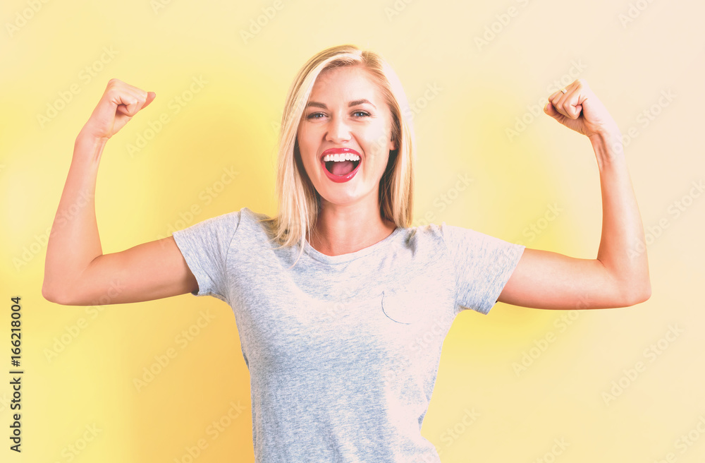 Powerful young woman on a yellow background