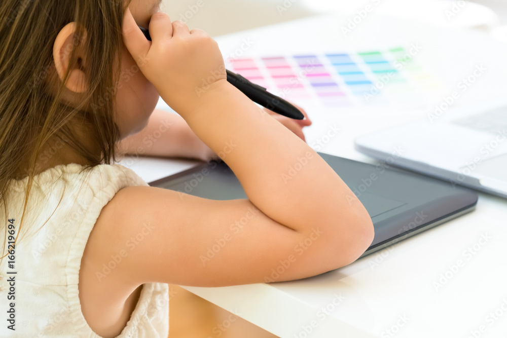 Little girl at her desk and computer at home