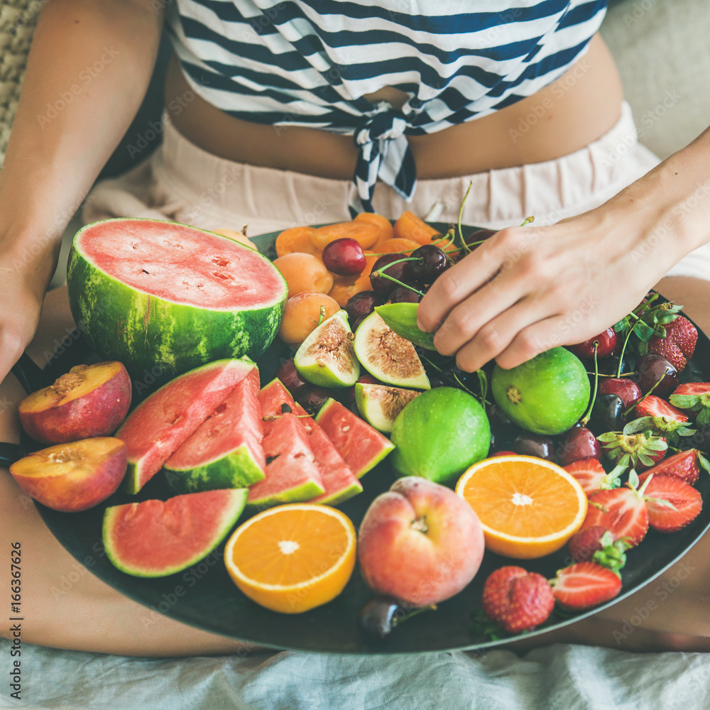 Summer healthy raw vegan clean eating breakfast in bed concept. Young girl wearing striped home shir