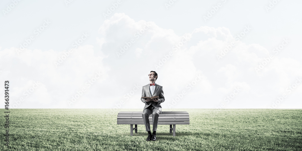 Young businessman or student studying the science in summer park