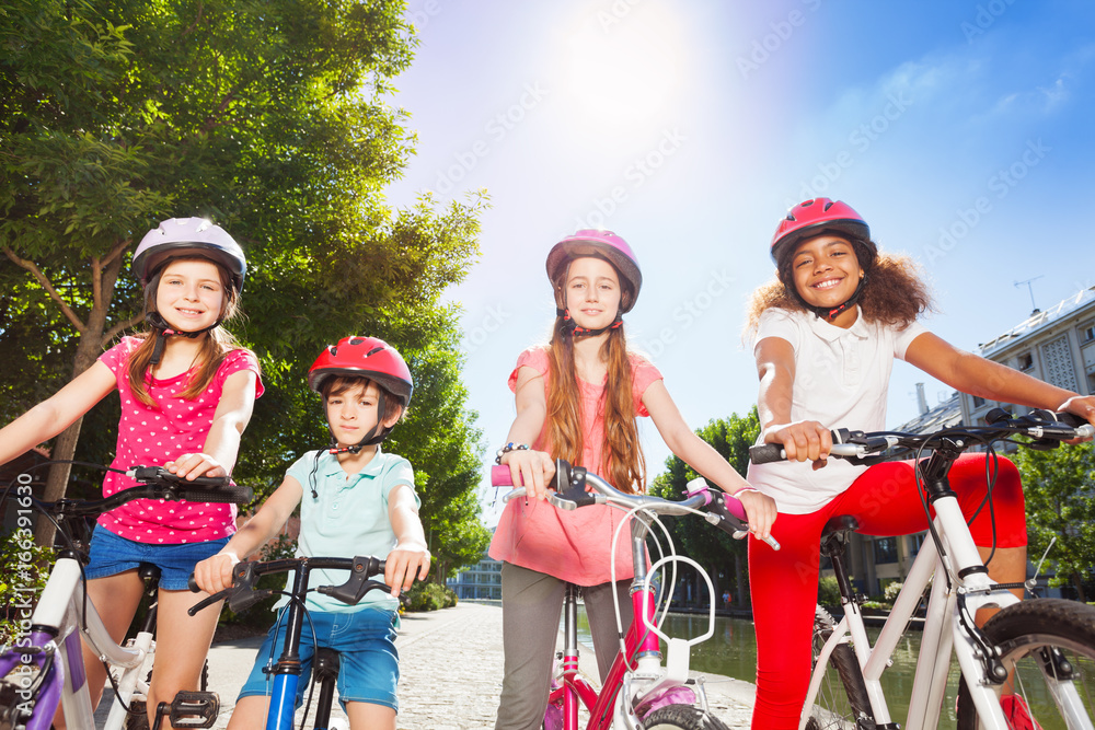 Happy bike riders standing together at summer park