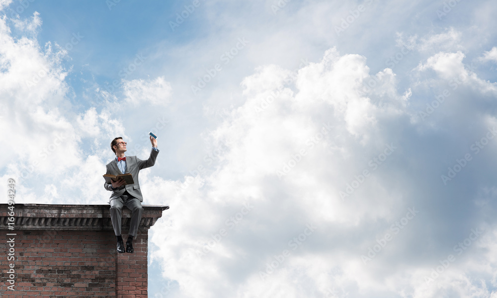 Young businessman or student studying the science on building roof