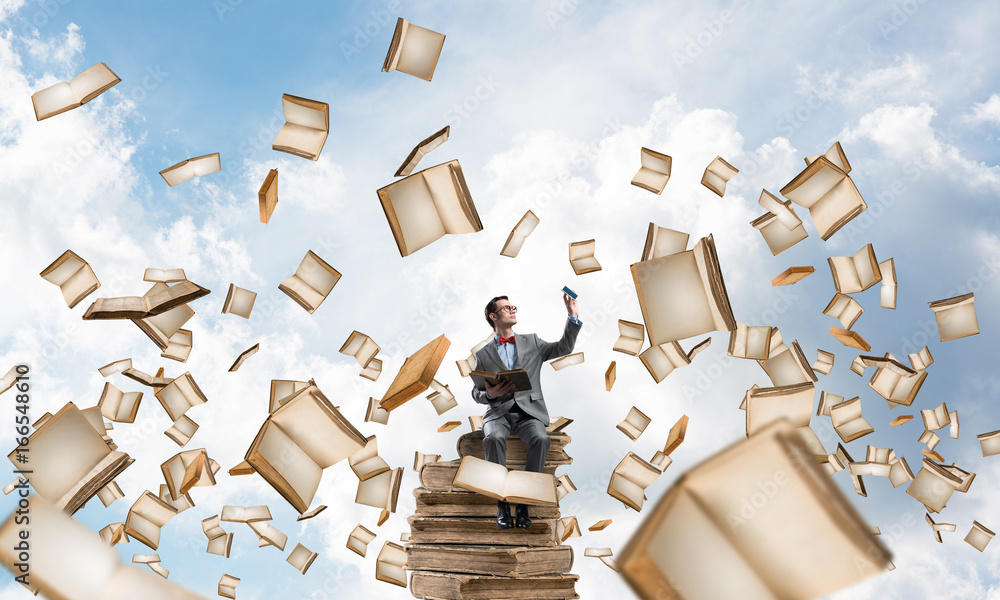 Young businessman or student studying the science and books fly around