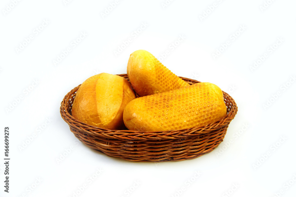 Whole wheat loaves and a bun on a wicker plate. White background isolated