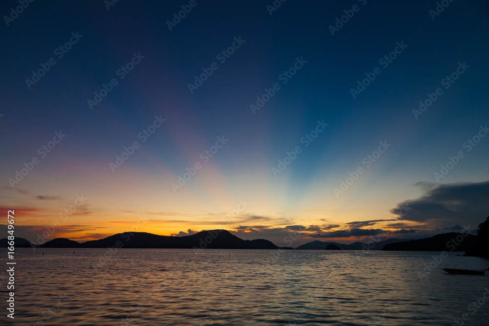 Beautiful colorful color and light sunset over tropical sea with reflection.