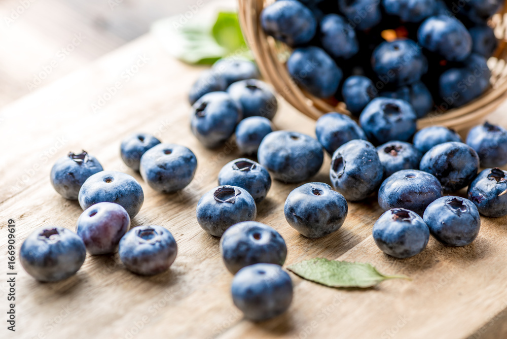 Freshly blueberries on wooden rustic wooden table. Juicy and fresh blueberries with green leaves. Bi