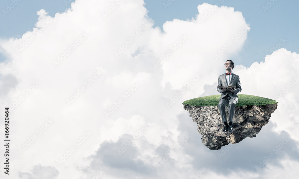 Young businessman or student floating in sky and studying the sc